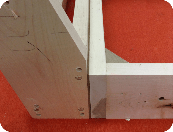 Assemblage des éléments du meuble par colle, goujons et visses