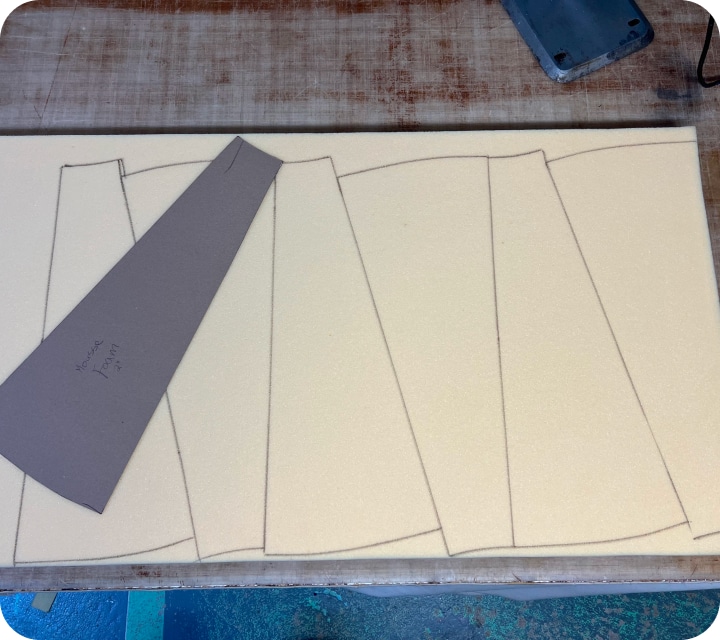 Tracing shapes onto polyurethane foam in preparation for cutting.